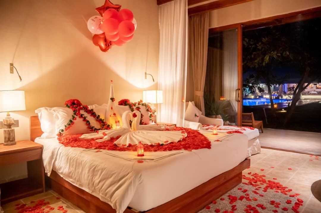 Honeymoon single room with rose petal heart design and warm night lighting at Entikko Safari Lodge Uganda