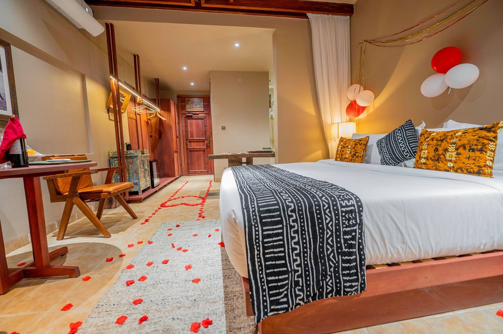 Wide view of romantic single room with rose petals and balloon décor at Entikko Safari Lodge near Murchison Falls Uganda