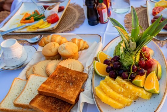 Healthy breakfast spread at Entikko Safari Lodge featuring fruits, biscuits, bread, and fresh juice