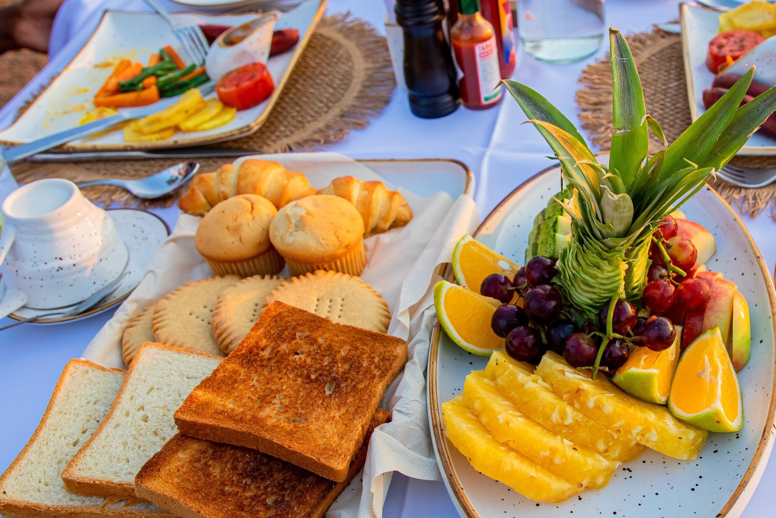 Healthy breakfast spread at Entikko Safari Lodge featuring fruits, biscuits, bread, and fresh juice