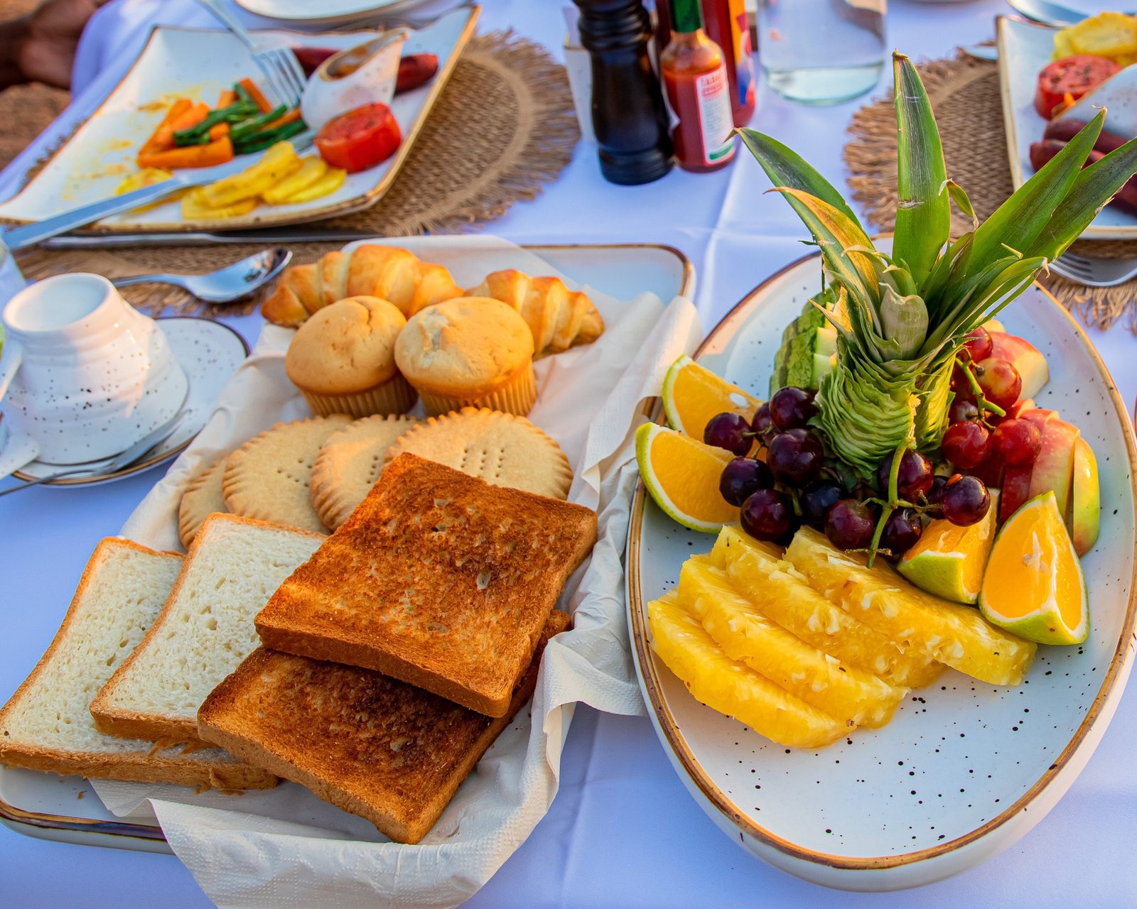 Healthy breakfast spread at Entikko Safari Lodge featuring fruits, biscuits, bread, and fresh juice