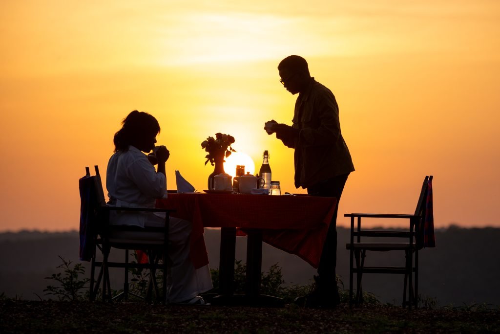 Couple enjoying romantic outdoor dining experience at Entikko Safari Lodge near Murchison Falls