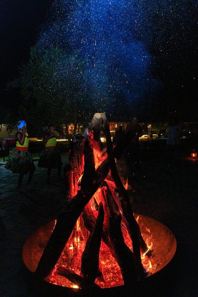 Guests enjoying a bonfire night at Entikko Safari Lodge with stargazing and storytelling under the African sky
