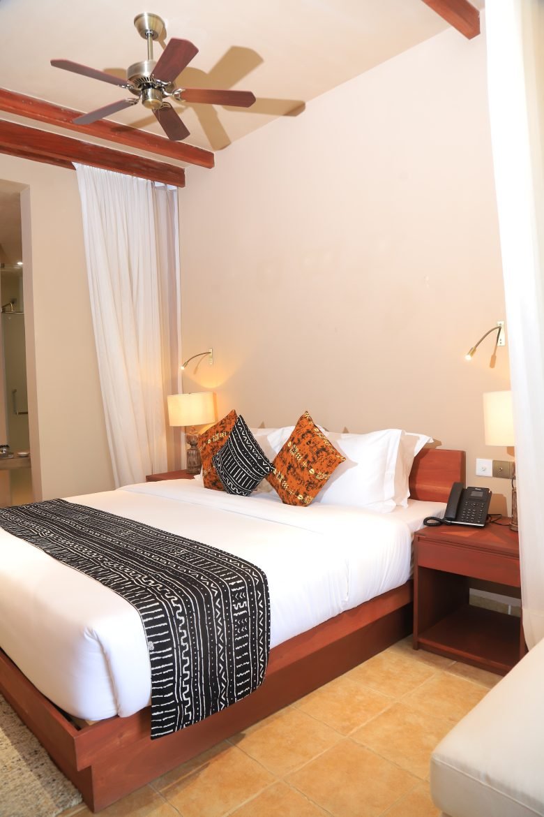 Single room at Entikko Safari Lodge with cozy bed and nature view