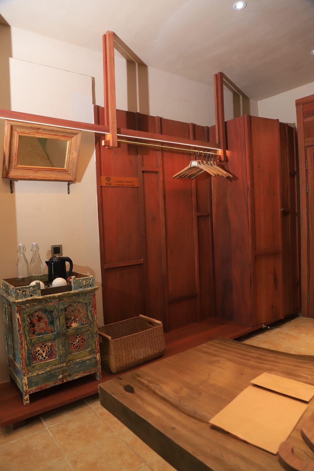 Built-in wardrobe inside single room at Entikko Safari Lodge with wooden finish and storage shelves