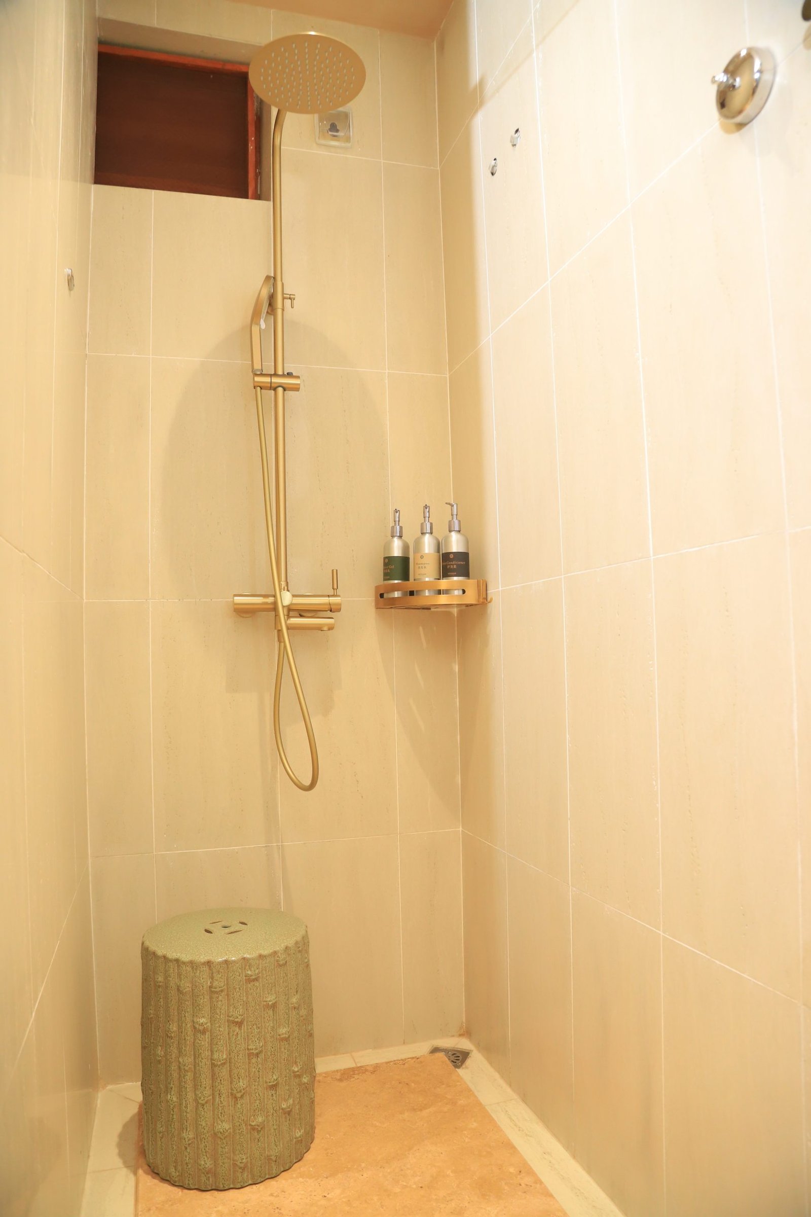 Private ensuite bathroom with shampoo bottles and soap on amenity deck with tiled walls and rainfall shower at Entikko Safari Lodge single room