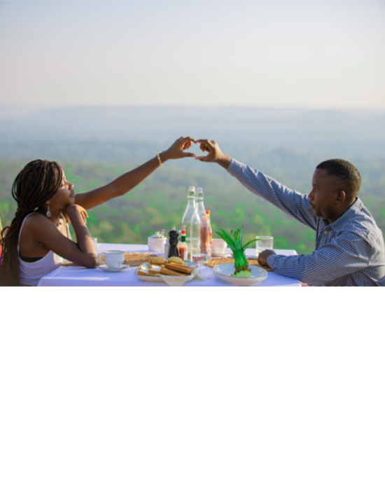 Couple enjoying a romantic sunset honey moon at Entikko Safari Lodge, making a heart shape with their hands.