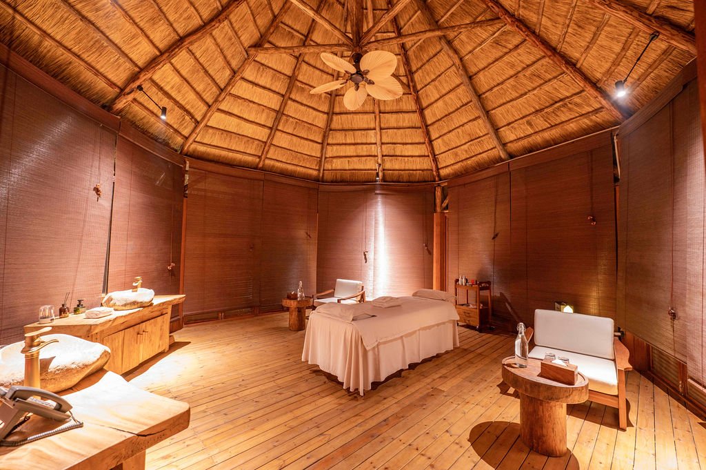 Luxury spa and massage suite with thatched roof and ambient lighting at Entikko Safari Lodge near Murchison Falls Uganda